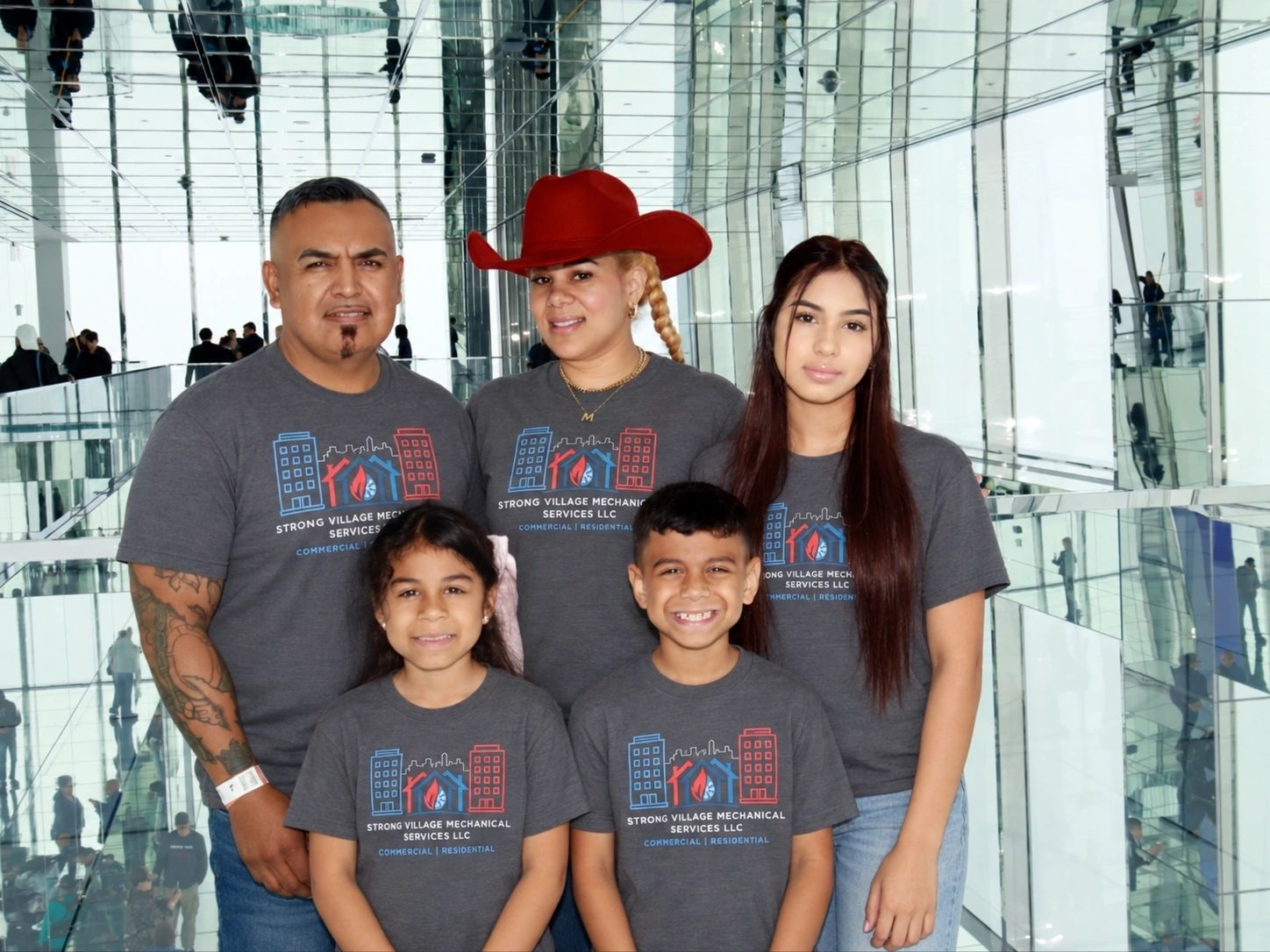 The Strong Village family wearing company shirts
